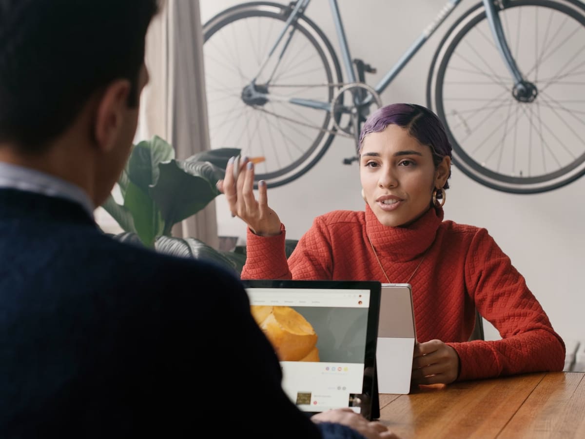 A warm editorial image of a person in thoughtful conversation over tea.